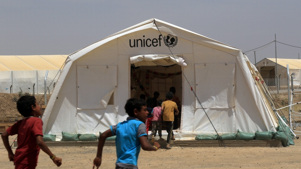Displaced Iraqi boys enter a tent school set by UNICEF at Hammam al-Alil camp south of Mosul