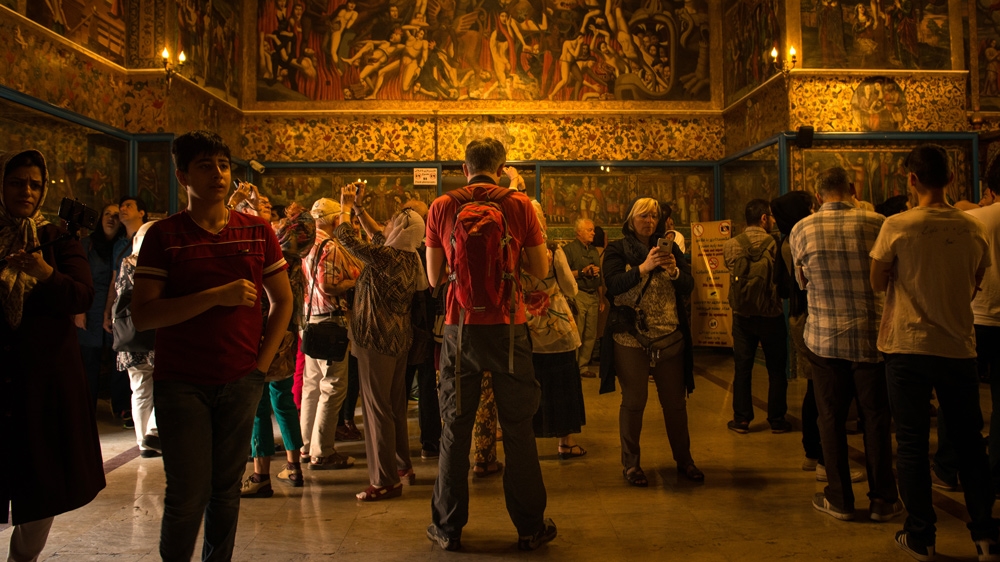 Tourists snap photos of the elaborate artwork inside one of Isfahan's historic churches [Wojtek Arciszewski/Al Jazeera]