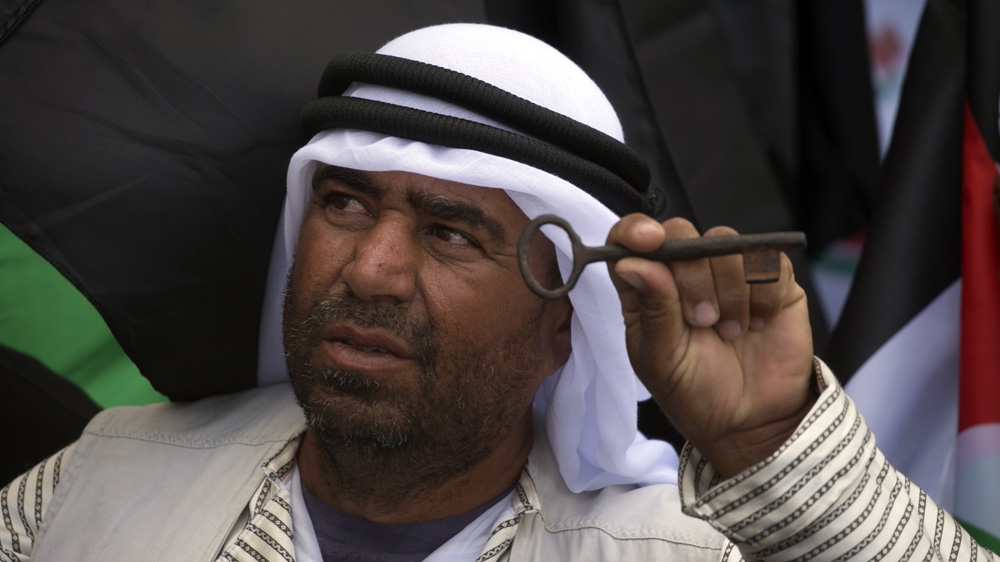 A Palestinian protester holds a key during a rally marking the 69th anniversary 