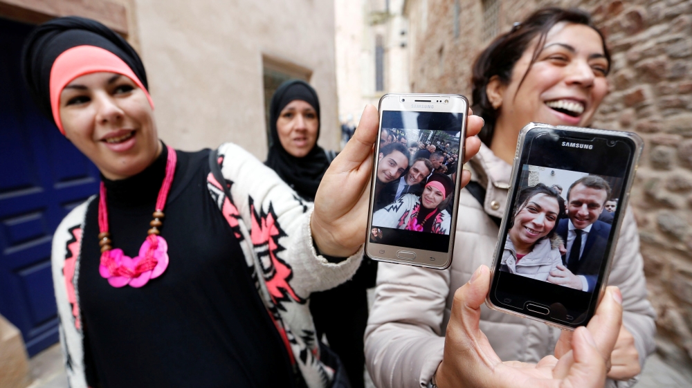 Macron supporters show off selfies taken with the presidential candidate [Regis Duvignau/Reuters] 