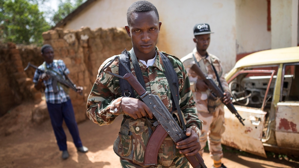 Armed fighters belonging to the 3R armed militia stands guard while their leader General Sadiki is talking to the media in the town of Koui, Central African Republic
