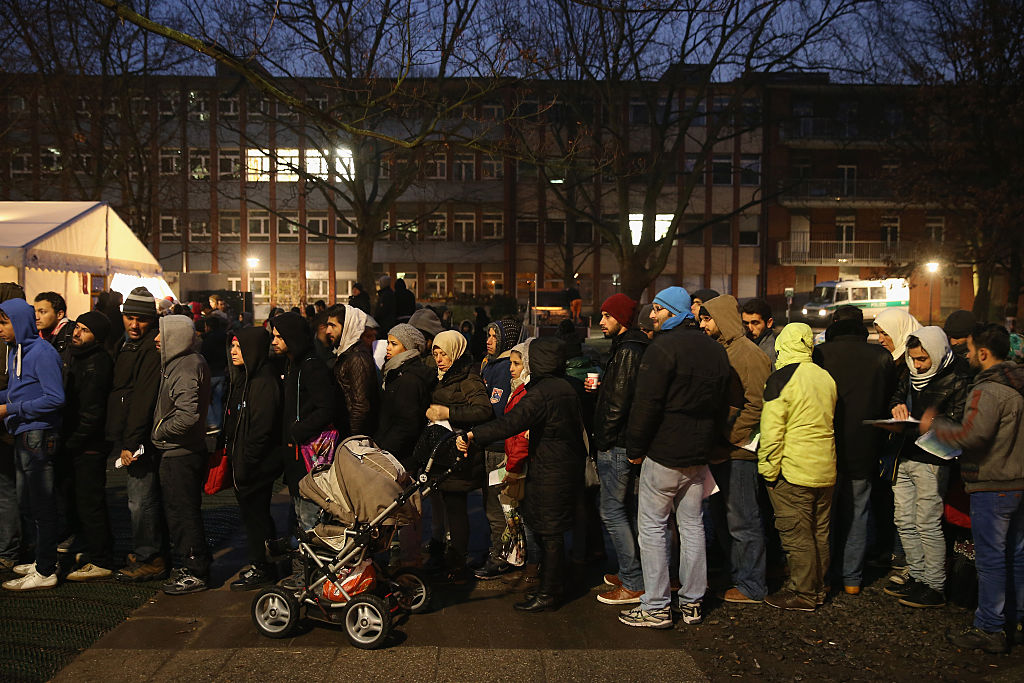Refugees wait outside the State Office of Health and Social Affairs in the early hours of December 9, 2015 [Sean Gallup/Getty Images]