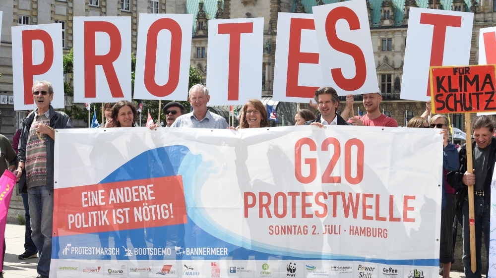 Protestors hold a banner in front of the townhall during a demonstration against the upcoming G20 summit in Hamburg