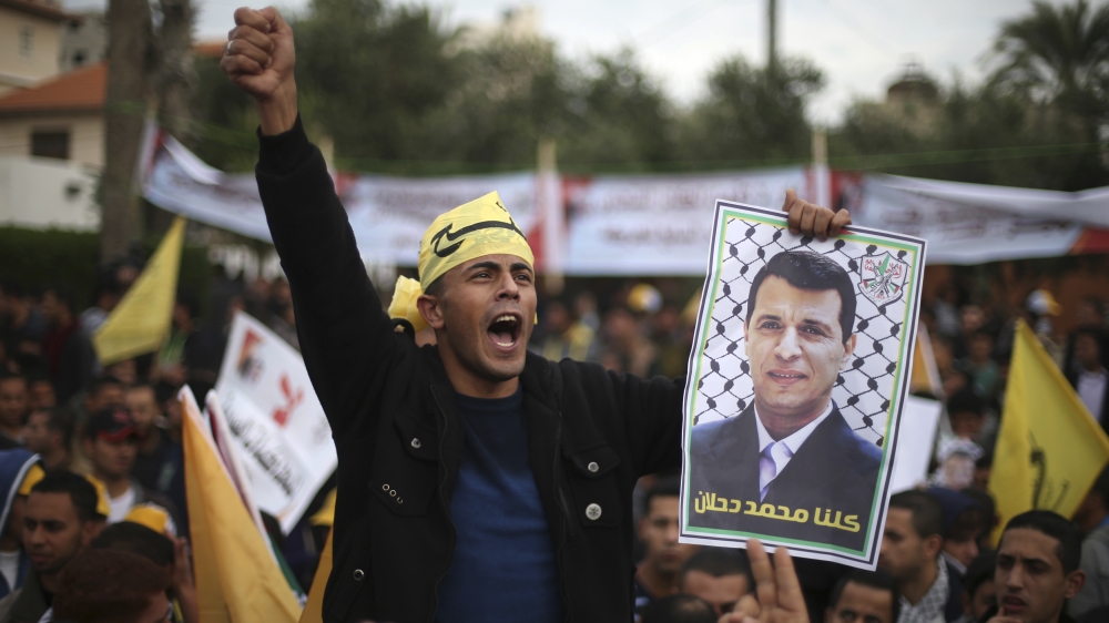 A Palestinian supporter of former head of Fatah in Gaza, Mohammed Dahlan, holds a poster during a protest against Palestinian President Mahmoud Abbas in Gaza City