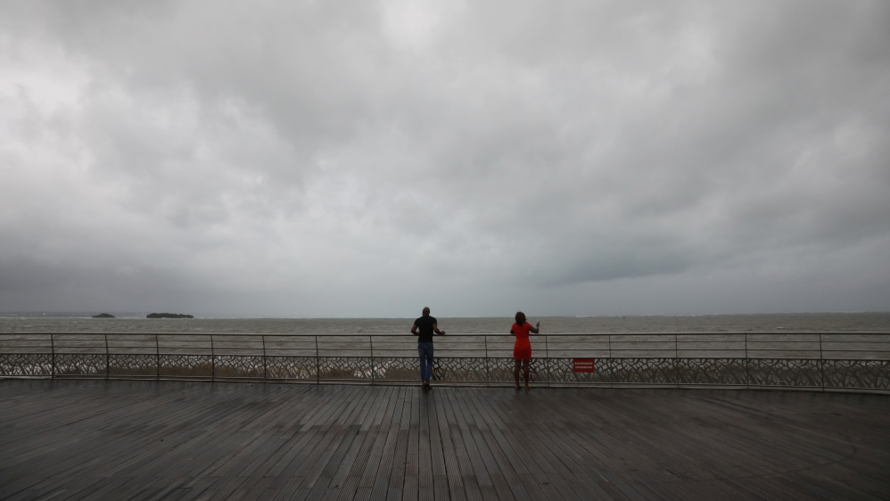 People look out at the ocean as Hurricane Maria approaches