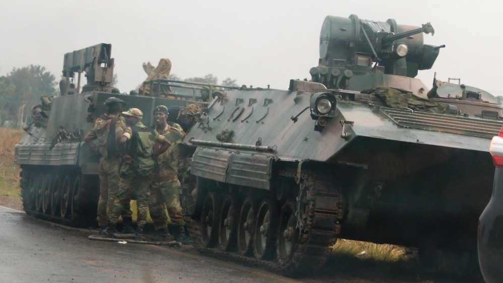 Soldiers stand beside military vehicles just outside Harare, Zimbabwe