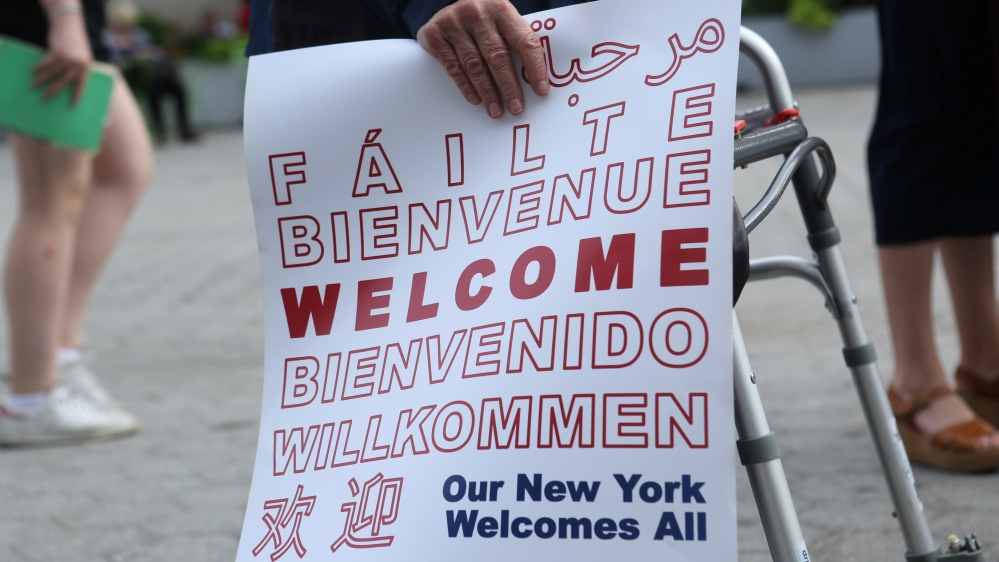 An protester holds a sign reading "Welcome" at a protest against U.S. President Donald Trump''s limited travel ban, approved by the U.S. Supreme Court, in New York City