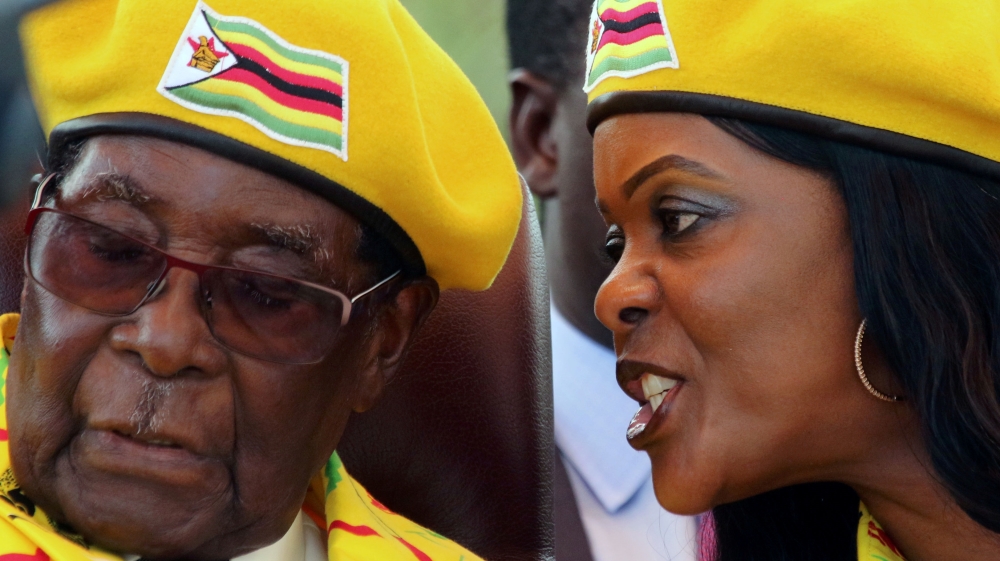 Mugabe listens to his wife Grace at a rally of his ruling ZANU-PF party [Philimon Bulawayo/Reuters]