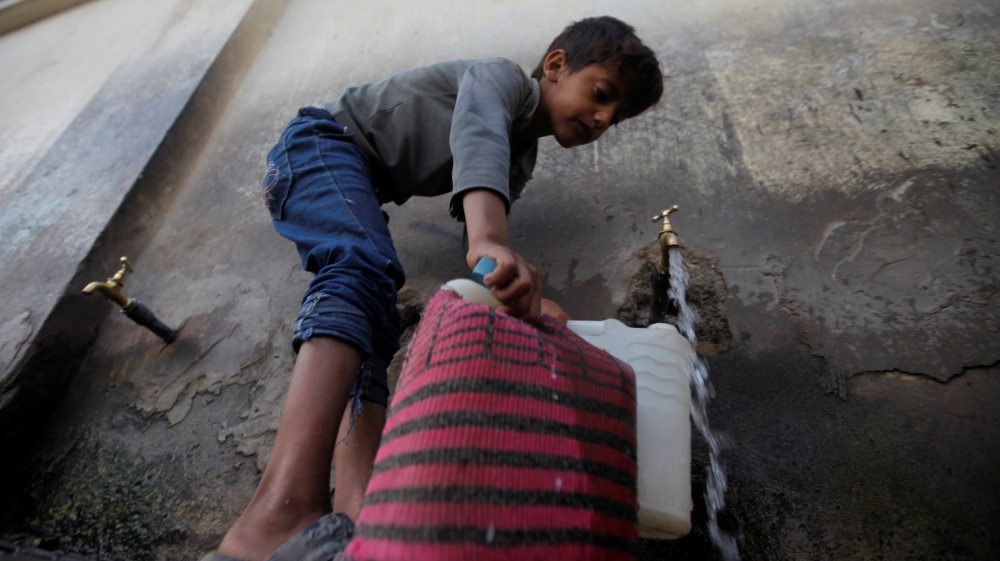A boy fills up a water container from a public tap, amid a cholera outbreak, in Sanaa