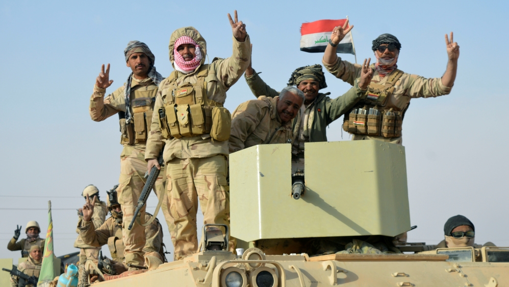 Iraqi forces show victory signs after they captured Rawa town