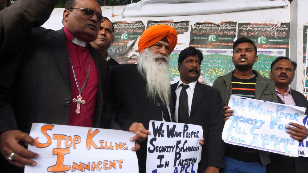 People hold signs for the victims who were killed [Akhtar Soomro/Reuters]