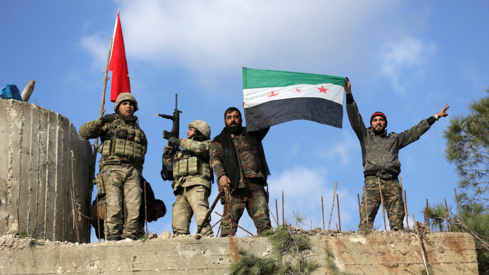Turkish forces and Free Syrian Army members hold flags on Mount Barsaya