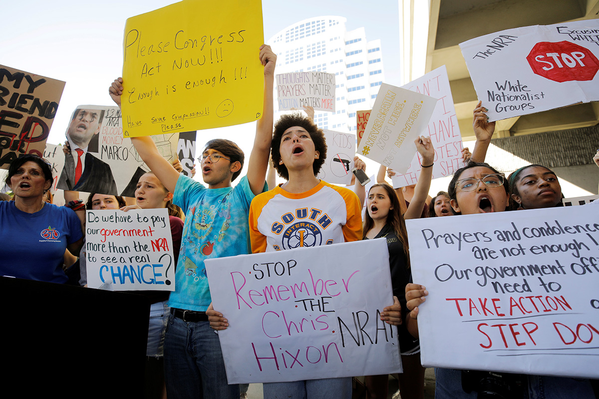 Students and others chant at a rally calling for