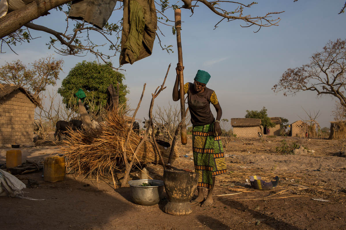 A displaced woman who has moved in with family members crushes cassava in Paoua town, Central African Republic, January 27, 2018. Cassava is a staple of the diet in rural CAR.