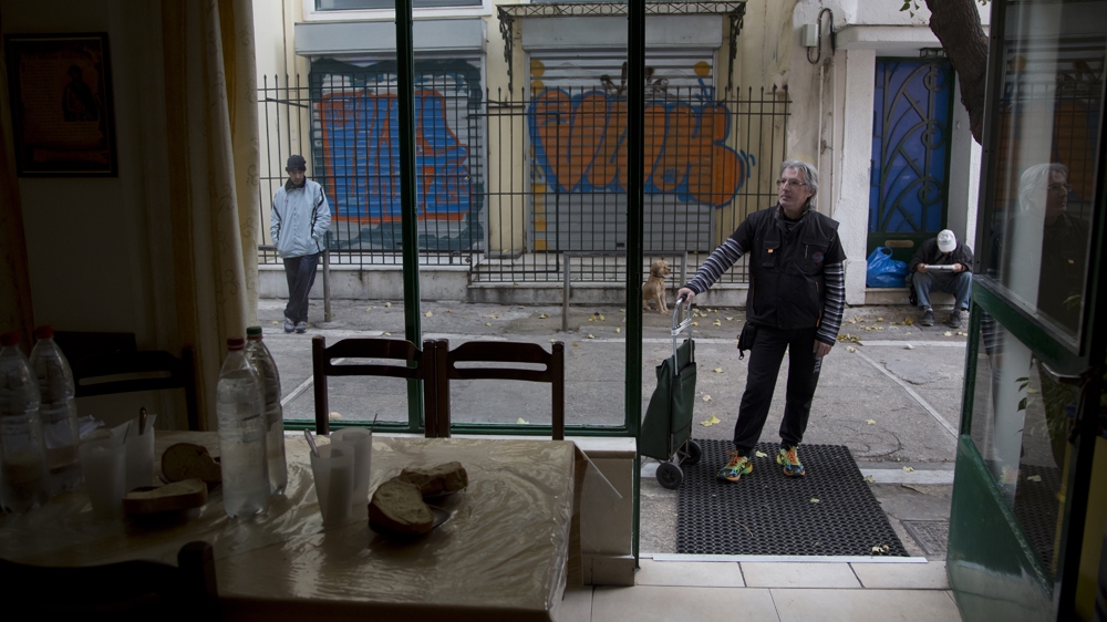 Filios waits outside a local bakery for a handout [Yannis Kolesidis/Al Jazeera] 