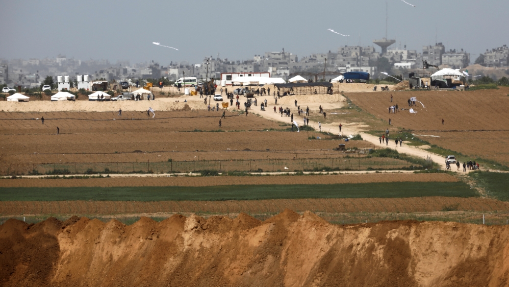 Palestinians walk near a tent camp on the Gaza side of the Israel-Gaza Strip border, as seen from the Israeli side of the border