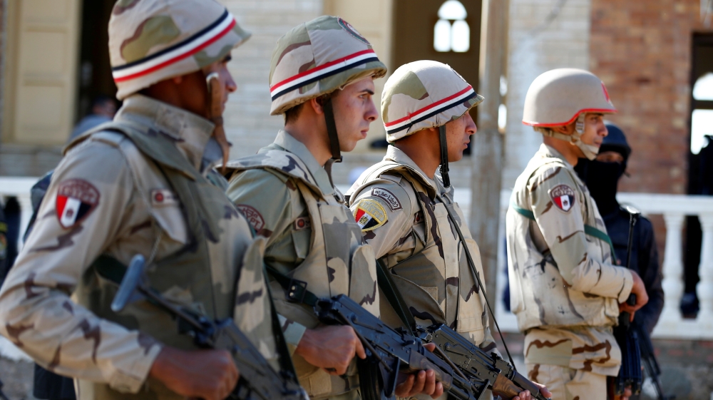 Military officers secure worshippers outside Al Rawdah mosque during the first Friday prayer after the attack in Bir Al-Abed