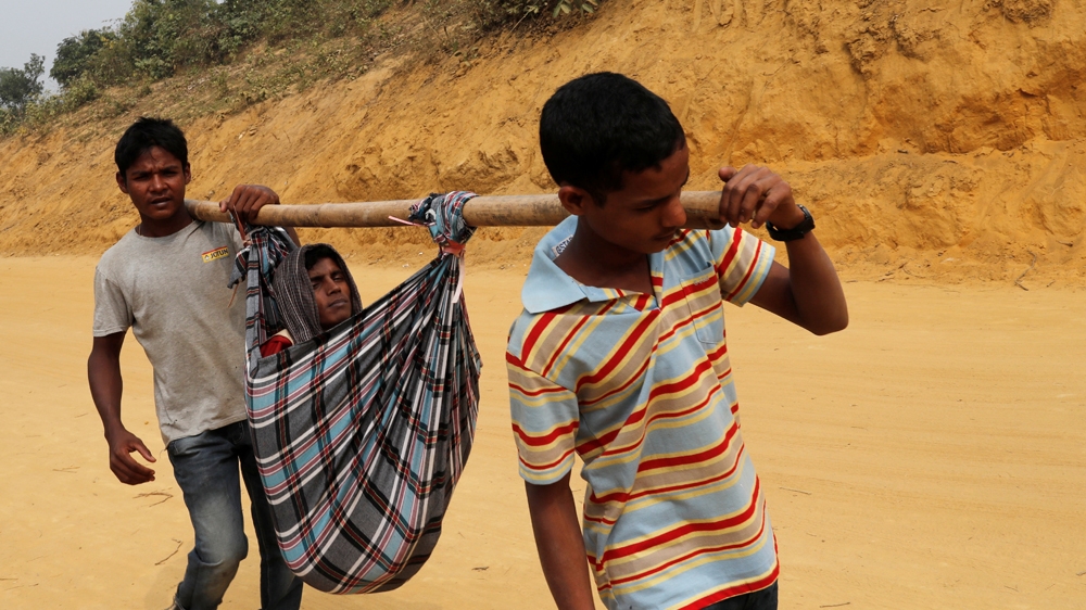 Rohingya refugees carry a sick refugee to hospital at Balukhali camp