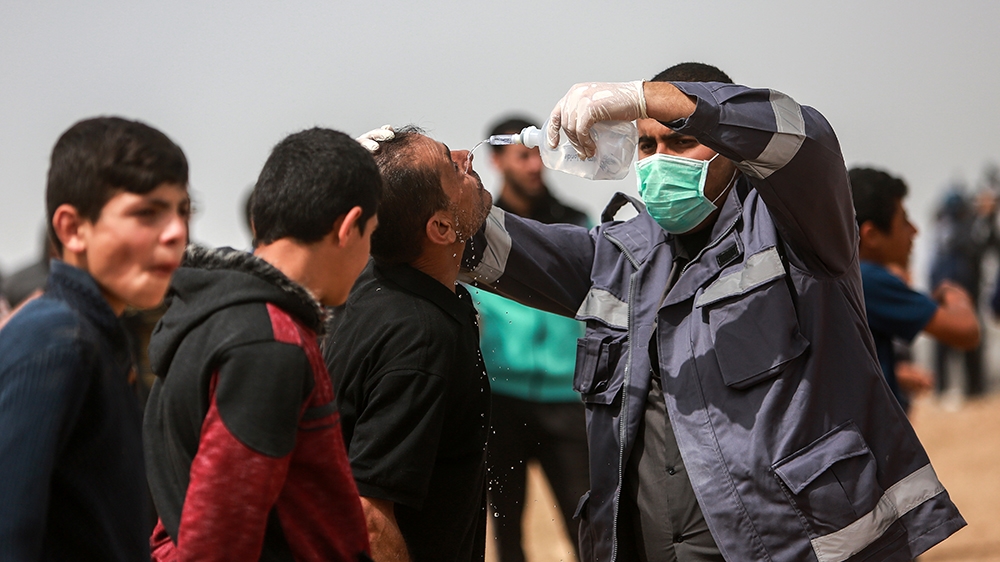 A man has his eyes cleaned after he was exposed to tear gas fired by Israeli soldiers [Hosam Salem/Al Jazeera]