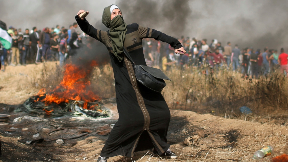 Girl hurls stones during clashes with Israeli troops at a protest where Palestinians demand the right to return to their homeland, at the Israel-Gaza border, east of Gaza City
