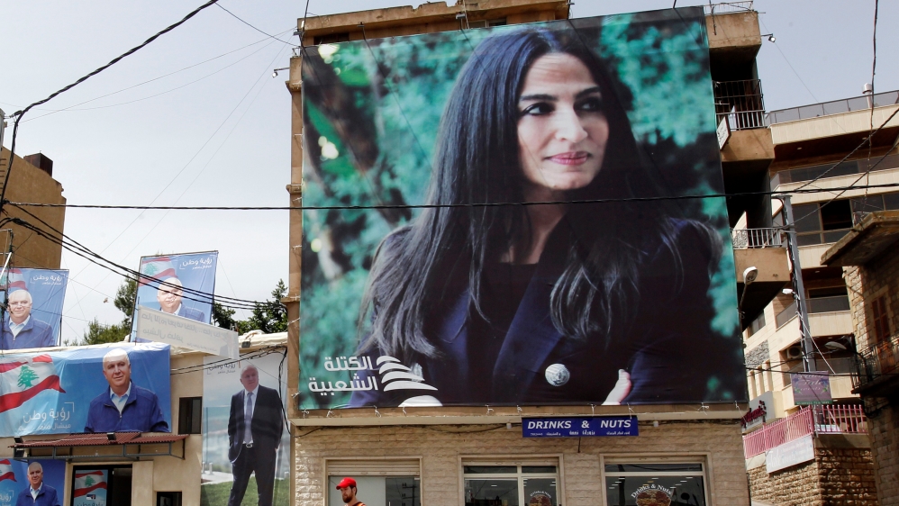 A man walks past campaign posters of Lebanese parliament candidates in the city of Zahle