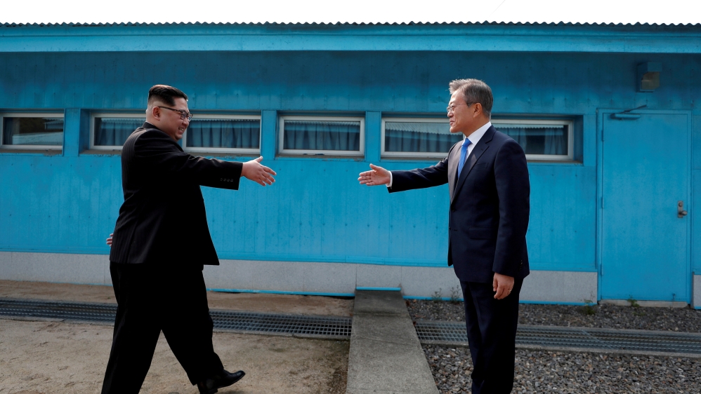 FILE PHOTO: South Korean President Moon Jae-in and North Korean leader Kim Jong Un about to shake hands for the first time at the truce village of Panmunjom