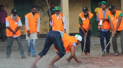 The local Tiger team practise with a 'human tiger'. The group consists of a network of volunteers dedicated to human-tiger conflict. [Phil Jones/ Al Jazeera]