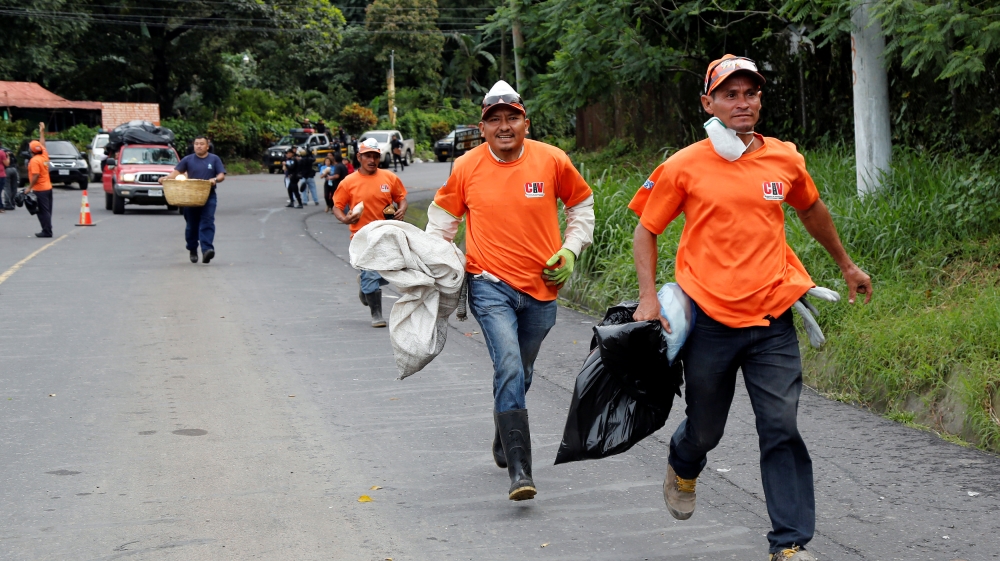 Workers flee as a lahar flows down from the Fuego volcano at El Rodeo in Escuintla