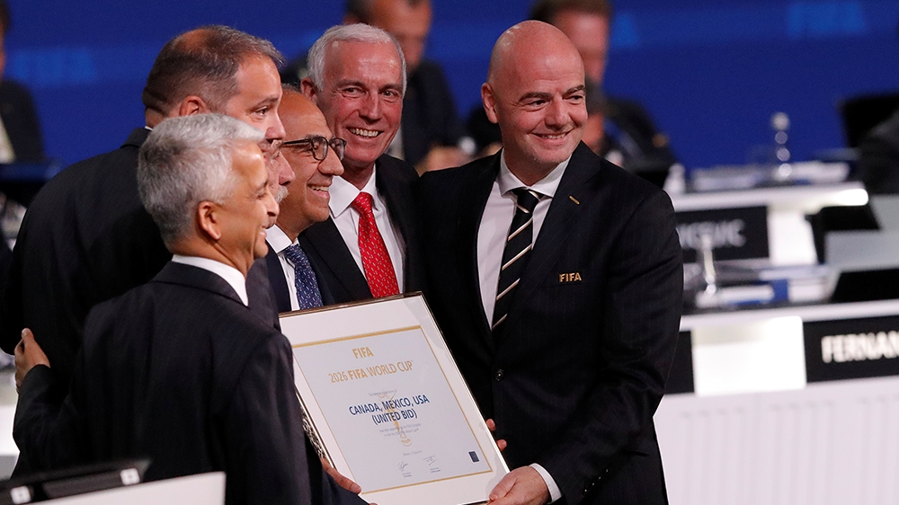 FIFA President Gianni Infantino (R) poses for a picture with officials after the announcement, that the 2026 FIFA World Cup will be held in the United States, Mexico and Canada, during the 68th FIFA C