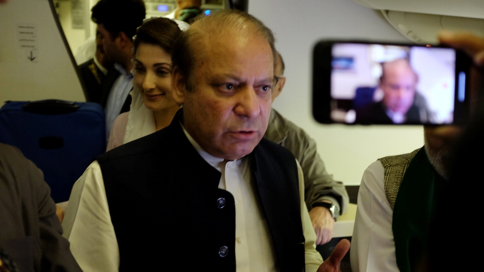 Ousted Pakistani Prime Minister Nawaz Sharif gestures as he boards a Lahore-bound flight due for departure, at Abu Dhabi International Airport