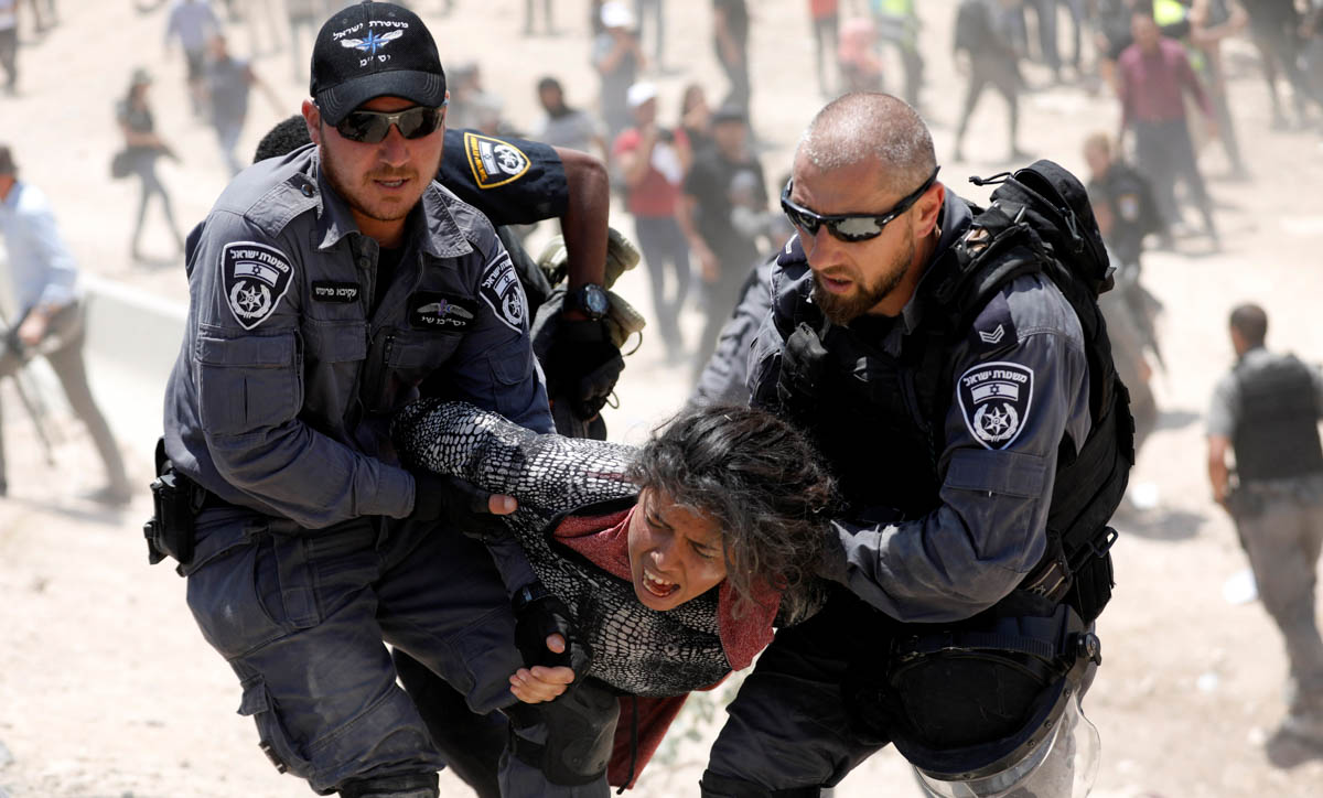 Israeli policemen detain a Palestinian girl in the Palestinian Bedouin village of al-Khan al-Ahmar near Jericho in the occupied West Bank July 4, 2018. REUTERS/Mohamad Torokman