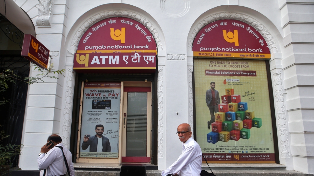 People walk past Punjab National Bank''s Brady House branch in Mumbai