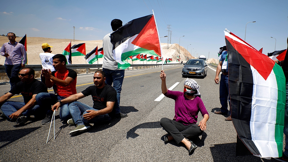 A demonstrator holds a Palestinian flag during a rally in support of Khan al-Ahmar residents in the Bedouin village of Khan al-Ahmar, in the occupied West Bank August 1, 2018. REUTERS/Mohamad Torokman