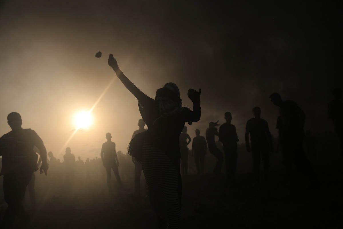 A Palestinian woman throws stones, August 31, 2018. Amnesty International declared that it "has not documented any instances where protesters posed an imminent threat to the lives of Israeli soldiers