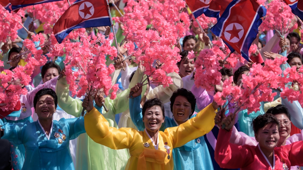 Thousands of civilians walked through the square waving bouquets [Ed Jones/AFP] 