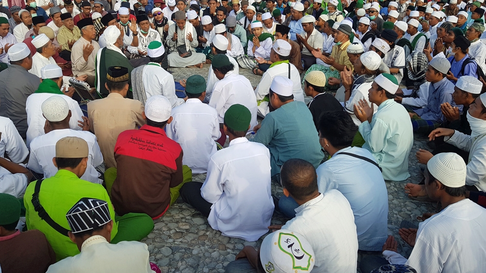 People attend a mass prayer for tsunami victims in Palu [Ted Regencia/Al Jazeera]