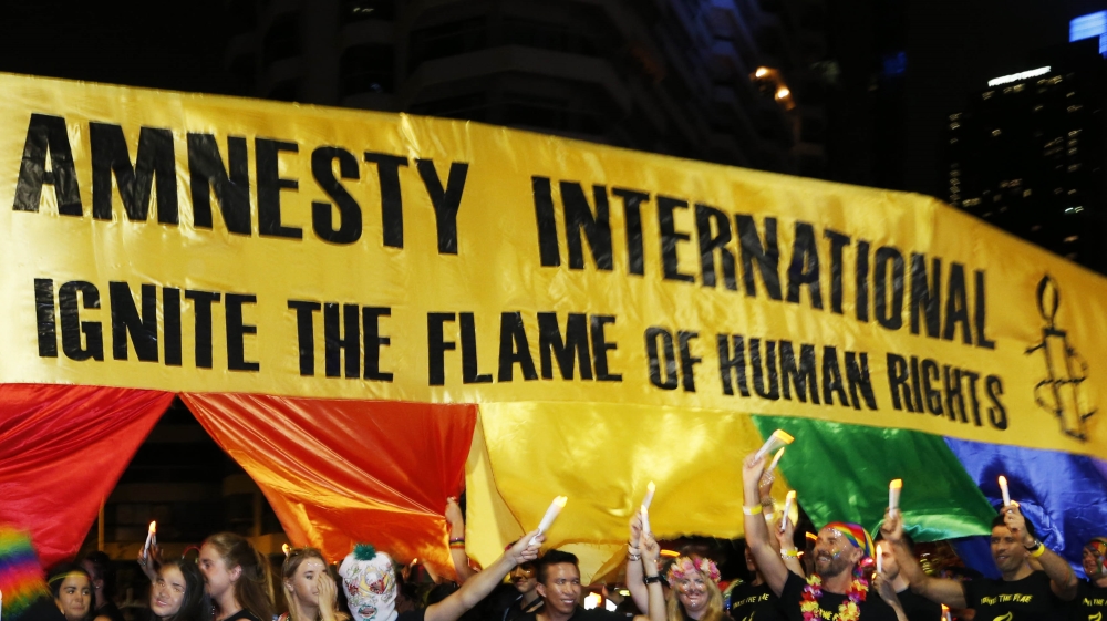 Participants at the 2014 Sydney Gay and Lesbian Mardi Gras march with a human rights banner for Amnesty International, March 1, 2014. REUTERS/Jason Reed