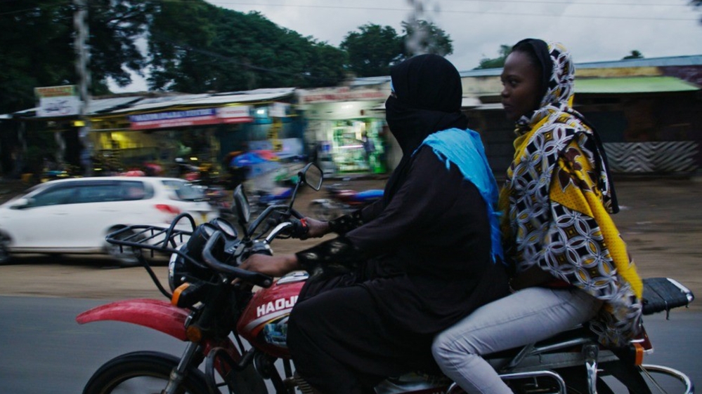 Former al-Shabab member Fatuma (L) has taken in two children whose parents abandoned them to join al-Shabab in Somalia. 'God has given me a second chance.' [Al Jazeera]