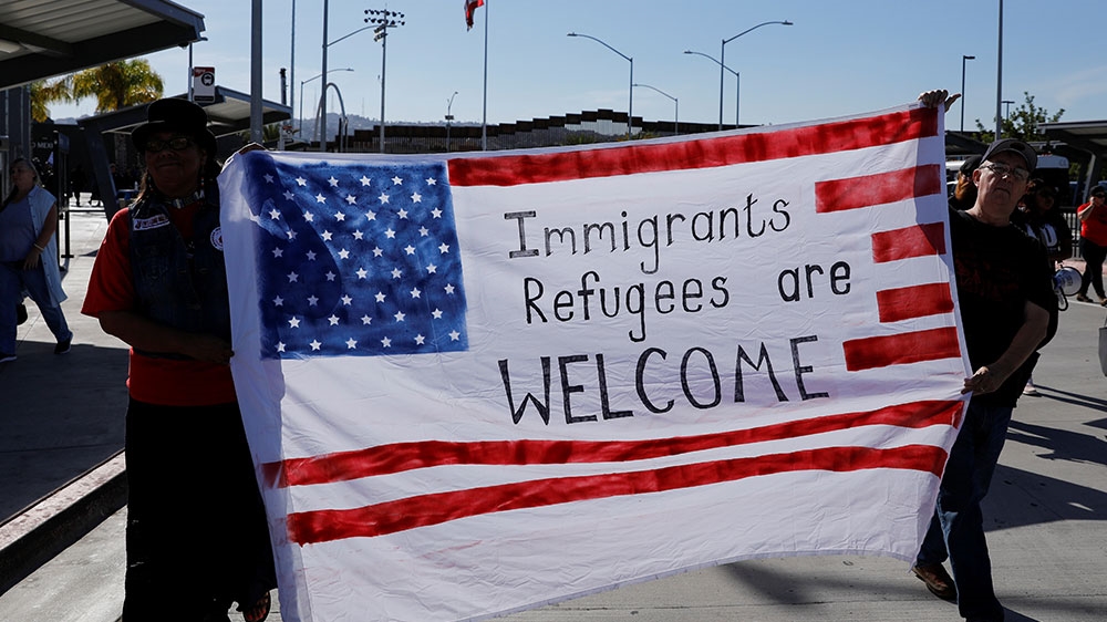 Protesters supporting the migrants and refugees in Tijuana, Mexico show their solidarity during a march next to the border wall with Mexico in the San Ysidro neighbourhood of San Diego [Mike Blake/Reuters] 
