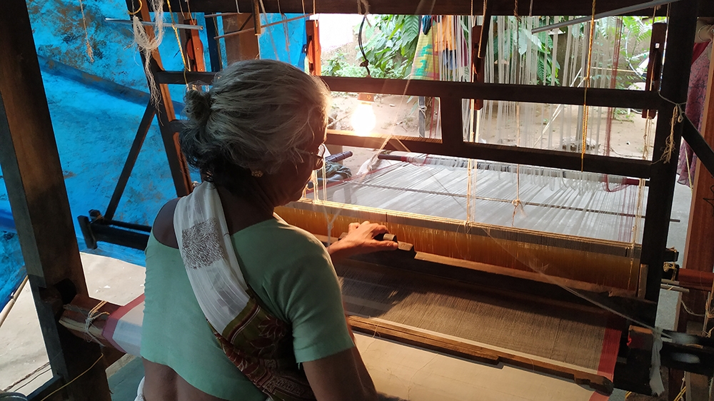 Ammini, 77, works on her repaired handloom [Jithin Shamsu/Al Jazeera]