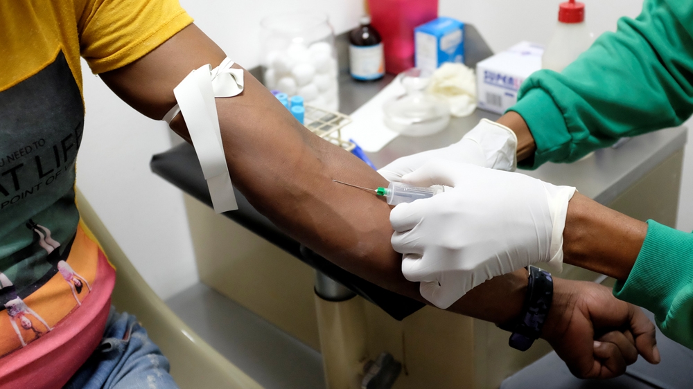 A nurse draws a blood sample for an HIV test