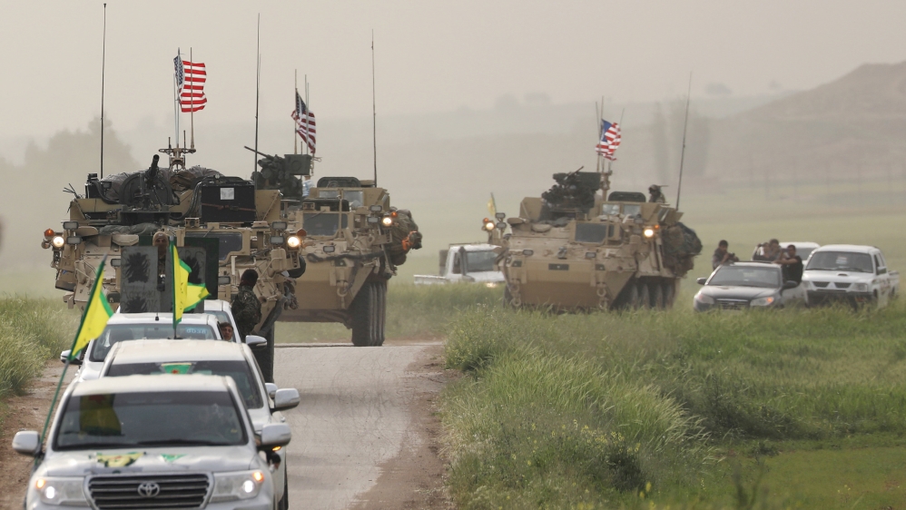 FILE PHOTO: Kurdish fighters from the People''s Protection Units (YPG) head a convoy of U.S military vehicles in the town of Darbasiya next to the Turkish border