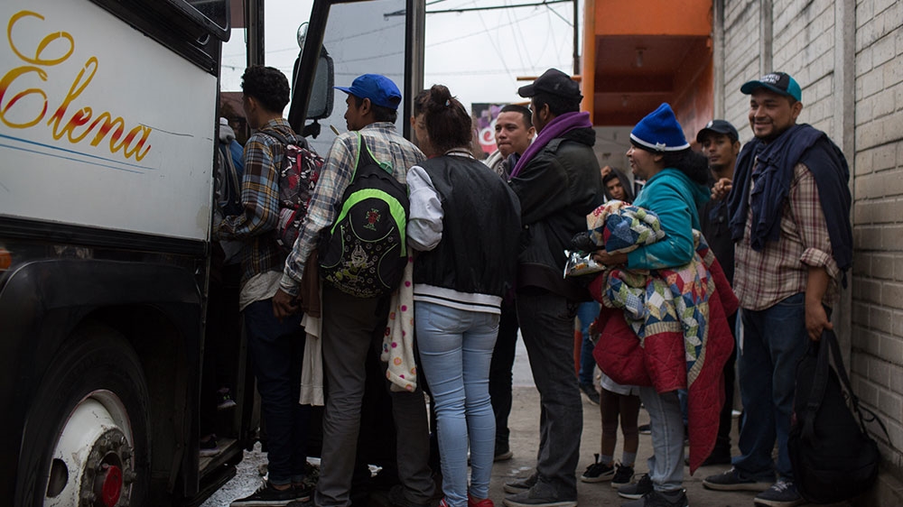 A group of Honduran migrants and refugees board a bus to the Guatemalan department of Peten [Jeff Abbott/Al Jazeera] 