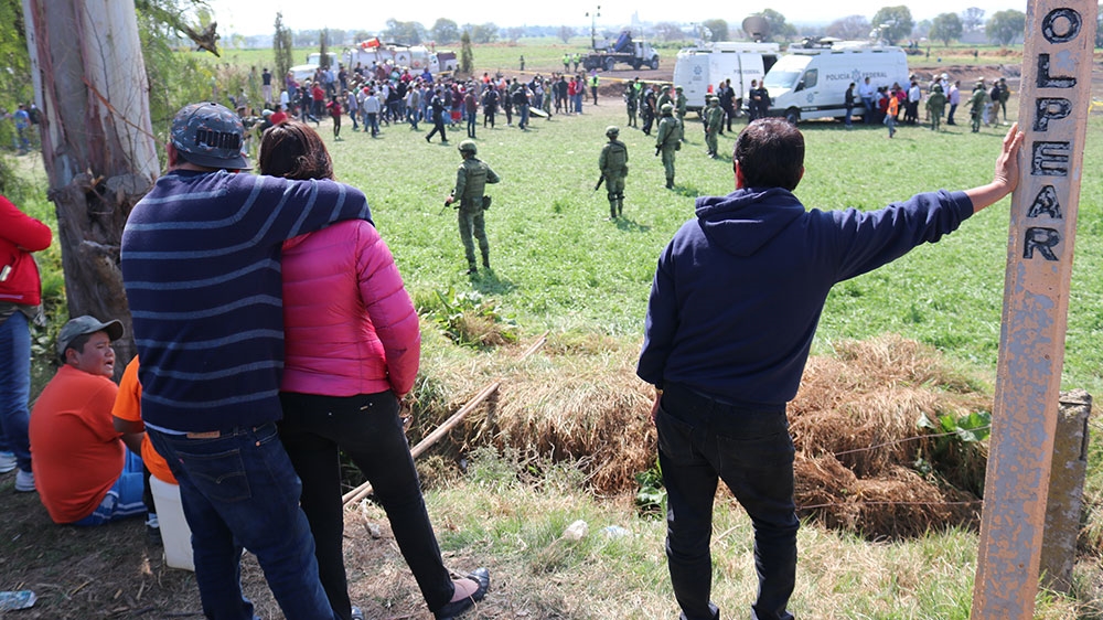 Bystanders look on at the scene of the explosion [Tm MacFarlan/Al Jazeera] 