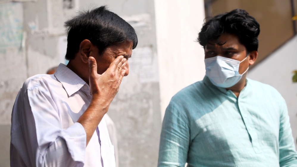 Relatives mourn after a fire broke out at a multistorey building in Dhaka [Mohammad Ponir Hossain/ Reuters]