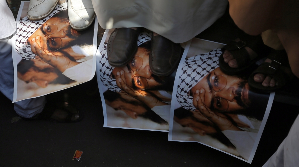 Demonstrators step on the posters of Maulana Masood Azhar, head of Pakistan-based militant group Jaish-e-Mohammad, during a protest in Mumbai