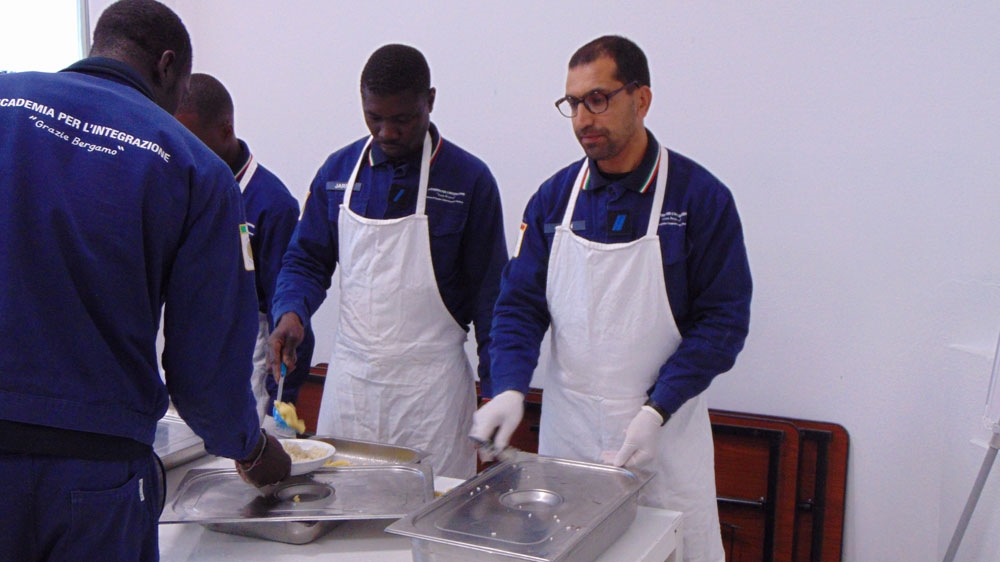 Khan, right, a Pakistani asylum seeker, says he wants to start working in Italy [Giorgio Ghiglione/Al Jazeera]