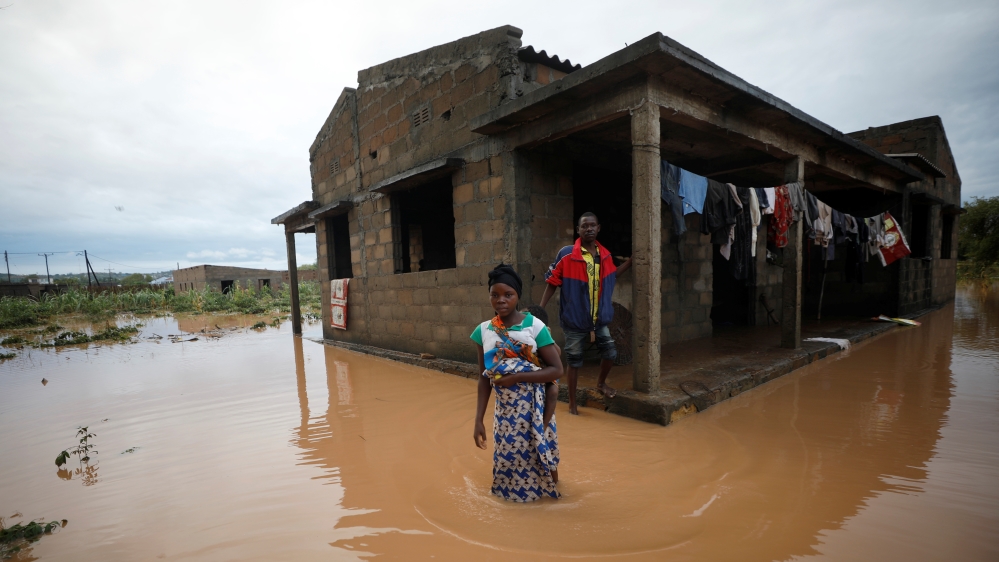 Agiro Cavanda and his wife Agera wade through floodwaters outside their home, flooded in the aftermath of Cyclone Kenneth, at Wimbe village in Pemba
