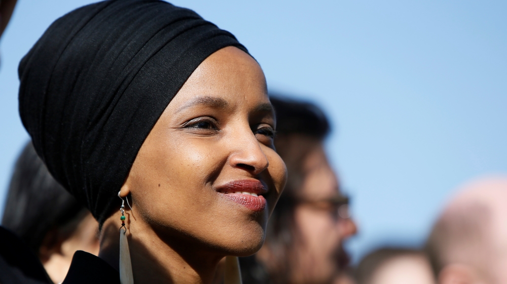 Rep. Omar smiles during at a news conference about Trump administration policies towards Muslim immigrants outside the U.S. Capitol in Washington