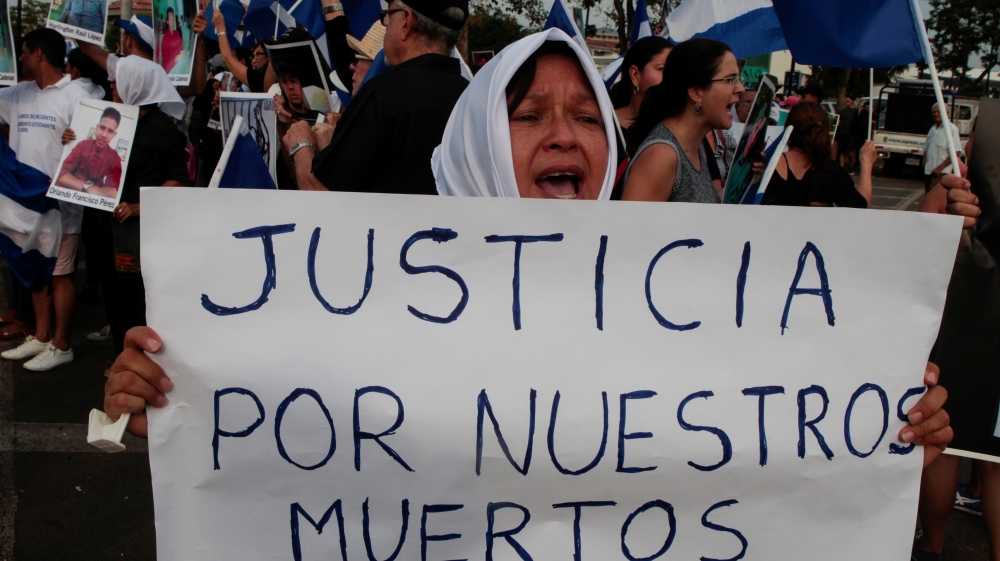 A woman holds a sign that reads 